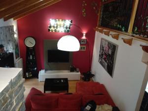 una sala de estar con paredes rojas y muebles de color rojo. en Agustina de Aragón, en Zaragoza