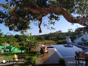 un patio trasero con piscina y un árbol en Villa Nobre Diniglei, en Trancoso