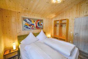 a bedroom with a white bed in a wooden wall at FBA Village in Bundenthal