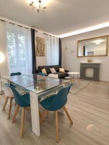 uma sala de estar com uma mesa de vidro e cadeiras em Deluxe Design - City Center Cosy Apartments em Colmar