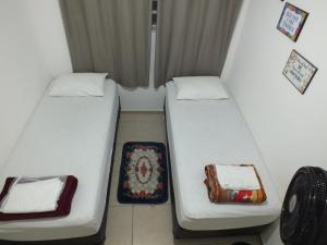 dos camas sentadas una al lado de la otra en una habitación en Hospedagem Henri Dunant, en São Paulo