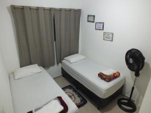 Habitación pequeña con 2 camas y ventilador. en Hospedagem Henri Dunant en São Paulo