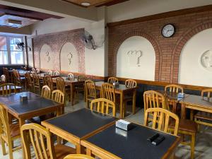 a restaurant with tables and chairs and a clock on the wall at Tony Center in Las Toninas