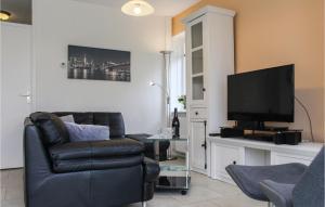 sala de estar con sofá y TV en Nice Home In Vlagtwedde With Kitchen, en Vlagtwedde