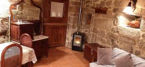 a room with a stone wall with a couch and a sink at Casa da Canella - En la Ribeira Sacra in Ourense