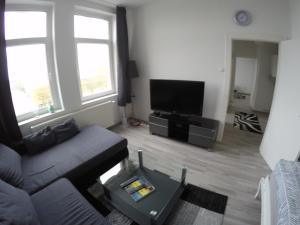 ein Wohnzimmer mit Couch und Flachbildfernseher in der Unterkunft Clean & Central 2 Room Apartment 50m² in Hannover