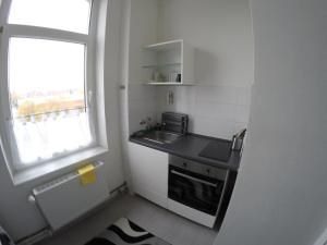 eine kleine Küche mit Spüle und Fenster in der Unterkunft Clean & Central 2 Room Apartment 50m² in Hannover + 3 Fotos