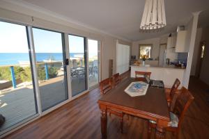 a kitchen and dining room with a table and a view of the ocean at Seascape Beach House in Boat Harbour