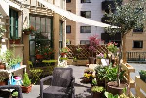 patio z krzesłami i roślinami doniczkowymi przed budynkiem w obiekcie Aloha Hostel w Pampelunie