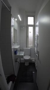 a bathroom with a toilet and a sink and a window at Clean & Central 2 Room Apartment 50m² in Hannover