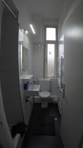 ein Badezimmer mit Toilette und Waschbecken und einem Fenster in der Unterkunft Clean & Central 2 Room Apartment 50m² in Hannover