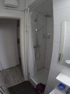 a bathroom with a shower with a glass door at Clean & Central 2 Room Apartment 50m² in Hannover