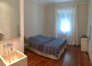 - une chambre avec un lit, une fenêtre et un lavabo dans l'établissement Le petit bourgeois de Nice, à Nice