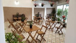 uma sala com mesas e cadeiras com vasos de plantas em Deck Hostel Congonhas em São Paulo