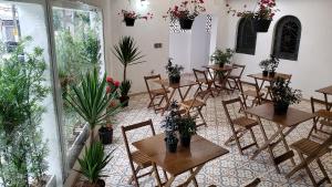Deck Hostel Congonhas في ساو باولو: مطعم بالطاولات والكراسي والنباتات الفخارية