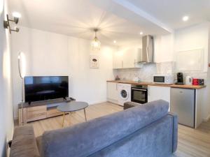 a living room with a blue couch and a kitchen at Charming Home - City Center Cosy Apartments in Colmar +47 photos