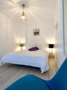 a white bedroom with a white bed and two lamps at Charming Home - City Center Cosy Apartments in Colmar