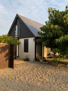 a home with a black and white house at Chalet bord de mer 6 couchages in Merville-Franceville-Plage