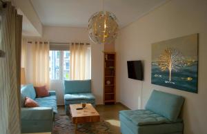 een woonkamer met twee blauwe stoelen en een tafel bij SUNNY CENTRAL LUXURY APARTMENT in Volos