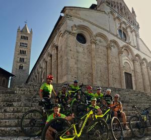 a group of people on bikes on steps in front of a church at Agriturismo Bike Hotel Podere Giarlinga in Massa Marittima