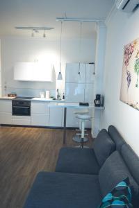 a living room with a couch and a kitchen at Stylisch eingerichtete Wohnung mitten in München! in Munich