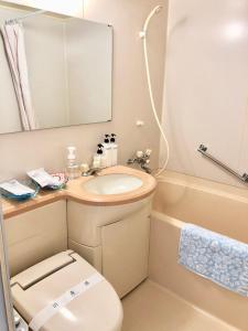 a bathroom with a toilet and a sink and a tub at Hotel Hoshitate Iriomotejima in Iriomote