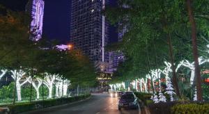 a city street at night with trees and lights at Dz Studio and Suite Parisien Tower i-City in Shah Alam