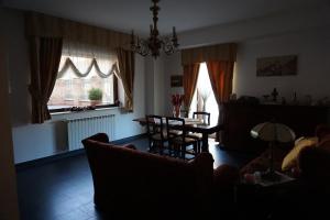 sala de estar con sofá, mesa y ventanas en Luxury B&B Dimora Albani, en Savignano Irpino