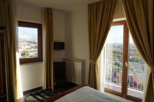 Habitación de hotel con cama y ventana grande en Luxury B&B Dimora Albani, en Savignano Irpino