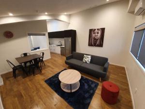 sala de estar con sofá y mesa en U Suites Kilbirnie, en Wellington