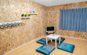 ONE HOSTEL Himeji في هيميجي: غرفة معيشة مع طاولة وتلفزيون