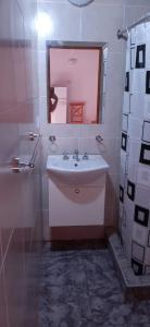 a white bathroom with a sink and a mirror at LOS AROMOS in Mar de Ajó