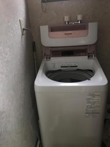 Un baño pequeño con un inodoro con la tapa levantada. en Sunny house, en Otaru