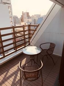 a table and two chairs on a balcony at WELLSTAY Honmachi in Osaka
