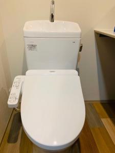 La salle de bains est pourvue de toilettes blanches avec télécommande. dans l'établissement WELLSTAY Honmachi, à Osaka 6 autres photos
