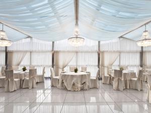 a marquee with white tables and chairs and chandeliers at Hotel Dei Principati in Baronissi