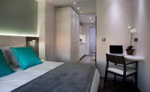 a bedroom with a bed and a desk with a laptop at Salamanca Suite Studios in Salamanca