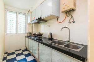 a kitchen with a sink and a counter top at Sanya Wen Xin Hai Jing Apartement in Sanya