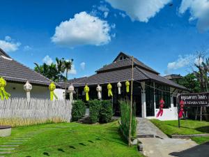 a house with a fence and yellow bows at Arun Dara Villa in Chiang Mai