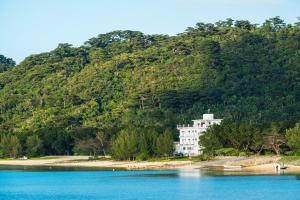 a large white building on the shore of a body of water at Hotel Hoshitate Iriomotejima in Iriomote