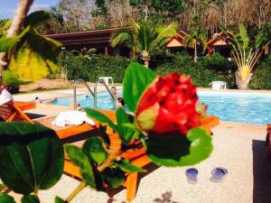 a flower sitting on a bench next to a swimming pool at Veranda Lanta Resort in Ko Lanta