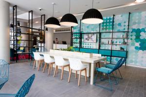 a dining room with a table, chairs, and a large mirror at ibis Styles East Perth in Perth