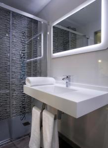 a bathroom with a white sink and a mirror at Salamanca Suite Studios in Salamanca