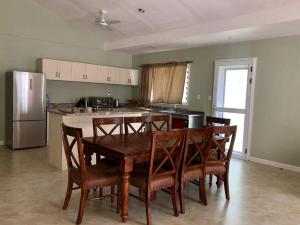 a kitchen with a table and chairs and a refrigerator at Lotopa Rambler in Apia