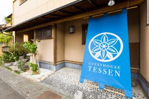 a sign for a guest house in front of a building at Tessen Guesthouse in Shizuoka