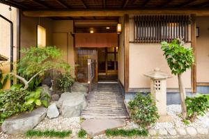 un edificio con una pasarela que conduce a una puerta en Tessen Guesthouse en Shizuoka