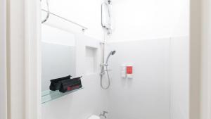 un bagno bianco con doccia e specchio di RedDoorz near Liceo De Cagayan University Highschool a Cagayan de Oro