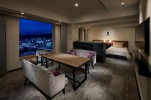 a hotel room with a bed and a table and chairs at Hotel Granvia Kyoto in Kyoto