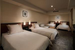 a hotel room with two beds and two lamps at Hotel Granvia Kyoto in Kyoto