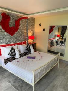 بيت الضيافة فونغ كايو آند بان نانغ فا في شاطيء باتونغ: غرفة نوم بها سرير كبير وعليها زهور حمراء